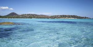 a large body of water with an island in the background at Les Jardins De Santa Giulia - Charmante chambre dhte in Porto-Vecchio