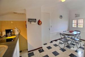 eine Küche mit Tisch und Stühlen in einem Zimmer in der Unterkunft Meublé trois étoiles au premier étage d’une maison typique in Saint-Cyprien