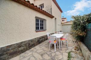 eine Terrasse mit Tisch und Stühlen vor einem Gebäude in der Unterkunft Meublé trois étoiles au premier étage d’une maison typique in Saint-Cyprien