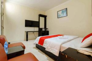 a bedroom with a bed and a chair in it at RedDoorz @ Dwipa Wisata Hotel in Lampung