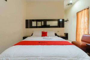 a bedroom with a large bed with a red pillow at RedDoorz @ Dwipa Wisata Hotel in Lampung