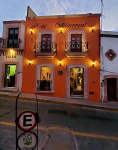 un bâtiment orange avec un panneau devant lui dans l'établissement Hotel Villarreal, à Zacatecas