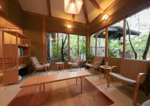 Habitación con sillas, mesas y ventanas. en Yufuin Onsen Hinoharu Ryokan, en Yufu
