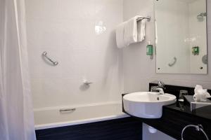 a bathroom with a sink, toilet and bathtub at Jurys Inn Cork in Cork