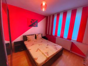 a bedroom with a bed with red and blue stripes at Apartament Sira in Sulina
