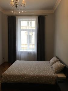 a bedroom with a bed in front of a window at APARTMENT ON CENTRE LVIV in Lviv