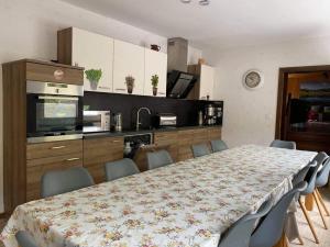 a room with a table and chairs and a kitchen at Freizeithaus Maranatha in Kirchhundem