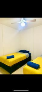 two beds in a room with yellow and blue pillows at Hogar Cálido y Acogedor in León