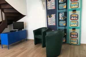 una sala de espera con 2 sillas y TV en LITTLE BIRD en Dinan
