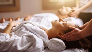 Una donna sdraiata su un letto sotto un asciugamano di WALLURE - Tickled Hotel & Wellness a Olbia