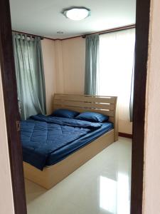 een slaapkamer met een bed met blauwe lakens en een raam bij บ้านชมวิว@แสมสาร in Ban Samae San