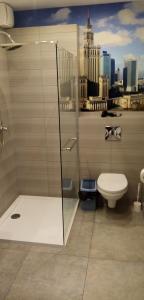 a bathroom with a toilet and a shower with a city skyline at Hostel Sunrise przy DW. Zachodnim in Warsaw