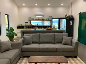 a living room with a couch and a kitchen at Millfield Garden Cottage in Millfield