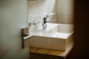 a bathroom sink with a faucet and a mirror at Hotel PINTE in Grindelwald