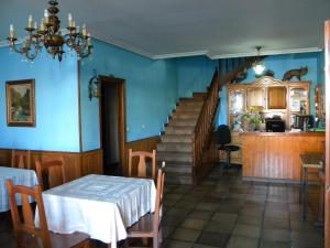 a dining room with blue walls and a staircase at Hotel Solymar in Bricia