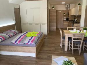 ein Schlafzimmer mit einem Bett und einem Tisch sowie eine Küche in der Unterkunft Apartment WELLNESS Vlčková in Vlčková