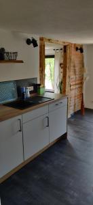 eine Küche mit weißen Schränken, einem Waschbecken und einem Fenster in der Unterkunft Ferienwohnung Oberposta in Pirna