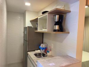a small kitchen with a sink and a refrigerator at Resort Île de Pipa Flat in Pipa