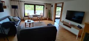 ein Wohnzimmer mit einem Sofa, einem TV und einem Tisch in der Unterkunft Ferienwohnung Oberposta in Pirna