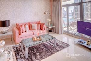 a living room with a pink couch and a tv at Dream Inn Apartments - Park Island in Dubai