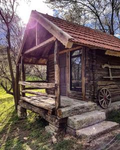 uma pequena cabana de madeira com um alpendre num campo em Tinutul Luanei Glamping Resort em Bozioru