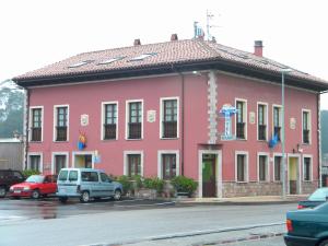a pink building with cars parked in front of it at Hotel Solymar in Bricia