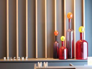 a group of four wine bottles sitting on a shelf at Hotel The M's Kyoto in Kyoto