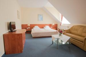 a hotel room with a bed and a couch at Hotel Daria in Tychy