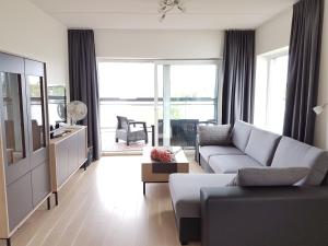 a living room with a couch and a large window at Riverstar in Pärnu