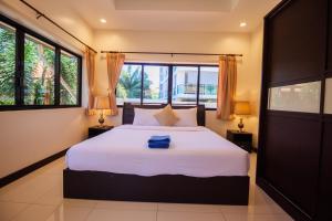 Un dormitorio con una gran cama blanca con dos lámparas. en Luxury Pool Villa 4 BR 900M beach 1.5 KM downtown, en Pattaya South 53 fotos más