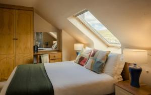 um quarto com uma cama com almofadas e uma janela em Seaview Heights em Dingle