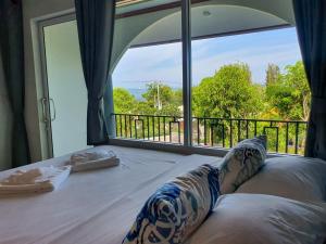 a room with a bed with a large window at Seattle Samaesarn Resort in Ban Samae San