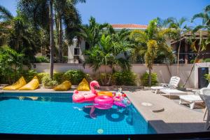 una piscina con flamencos rosas inflables en un complejo en Luxury Pool Villa 4 BR 900M beach 1.5 KM downtown, en Pattaya South