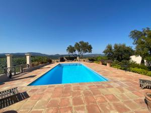 a swimming pool on a patio with two chairs at Gites De La Galline in La Môle