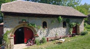 a small stone building with a red door at Rajacke pivnice Country House C`est La Vie in Rajac