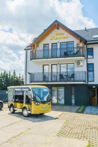 a yellow truck parked in front of a building at APARTAMENTY PIAMOLA Willa Zacisze Kąty Rybackie in Kąty Rybackie