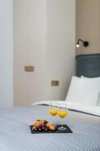 ein Tablett mit Essen und zwei Weingläsern auf dem Bett in der Unterkunft River city apartments No 4 by URBAN RENT in Kaunas
