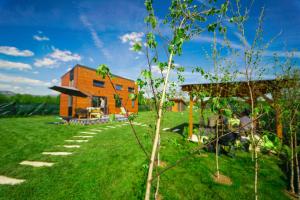 a house in a yard with a tree at Tiny House - Baia de Fier in Baia de Fier