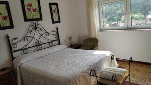 Schlafzimmer mit einem Bett und einem Fenster in der Unterkunft Casa Divina Elías Sixto Pampín in Cee