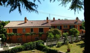 an orange house with a fence in front of it at Residence Villa Maria in Monrupino