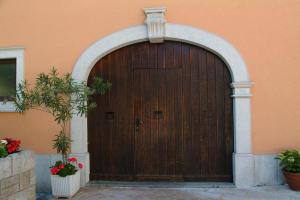 a wooden door of a building with two potted plants at Residence Villa Maria in Monrupino
