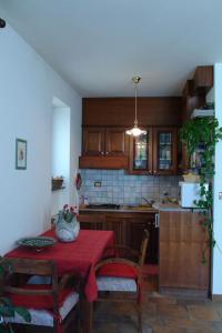 a kitchen with a table with a red table cloth at Residence Villa Maria in Monrupino