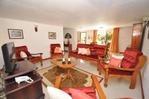 een woonkamer met meubilair en een televisie bij Chrisent Residence in Port Glaud