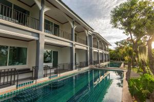 an exterior view of a building with a swimming pool at Seattle Samaesarn Resort in Ban Samae San