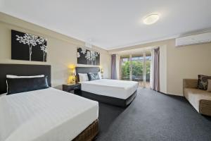 
a bedroom with a large bed and a large window at Ambassador On Ruthven in Toowoomba
