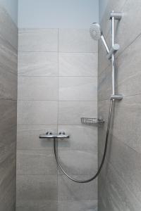 y baño con ducha con cabezal de ducha. en River city apartments No 1 by URBAN RENT en Kaunas