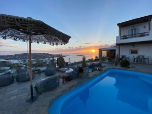 a villa with a swimming pool and a sunset at Chill Out Studio in Mýkonos City