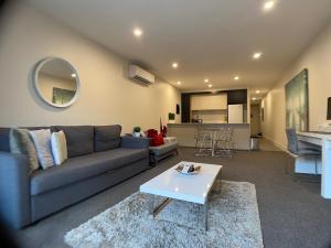 un soggiorno con divano e tavolo di The Gallery Luxe 1 BR Executive Apartment in the heart of Braddon Wine Secure Parking WiFi a Canberra