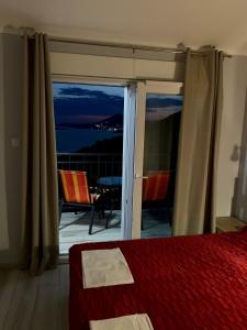 a bedroom with a bed and a view of the ocean at Apartments MM in Sveti Stefan