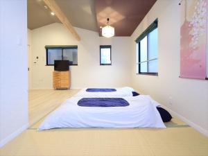 Dos camas en una habitación grande con TV. en COTO Tokyo Asakusa 4, en Tokio